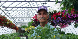 Man holding a vegetable hanging basket.