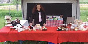 Woman behind a table with homemade goods