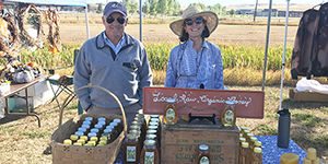 Couple behind a table with honey products