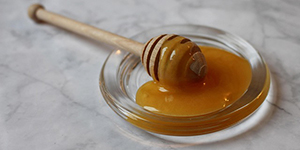 Honey in a bowl with a honey spoon