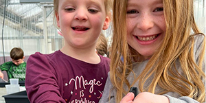 Two girls holding a worm