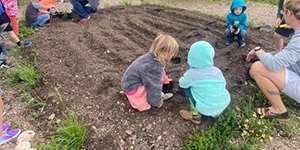 Kids planting in a garden