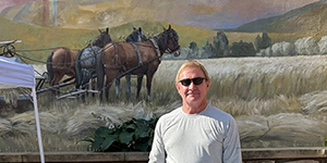 Man in front of mural at Farmer's Market