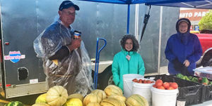 Family behind table of produce