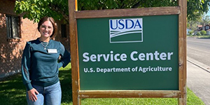 Woman standing next to USDA Service Center sign