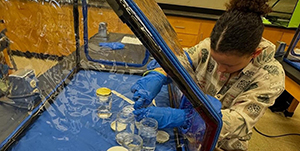 Student working with plants in a lab.