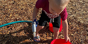 Child filling bucket with water