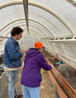 Two people working in a hoop house.