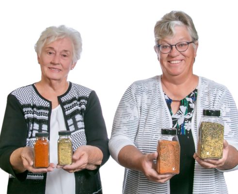 Two ladies holding canned goods.