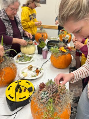 People decorating pumpkins