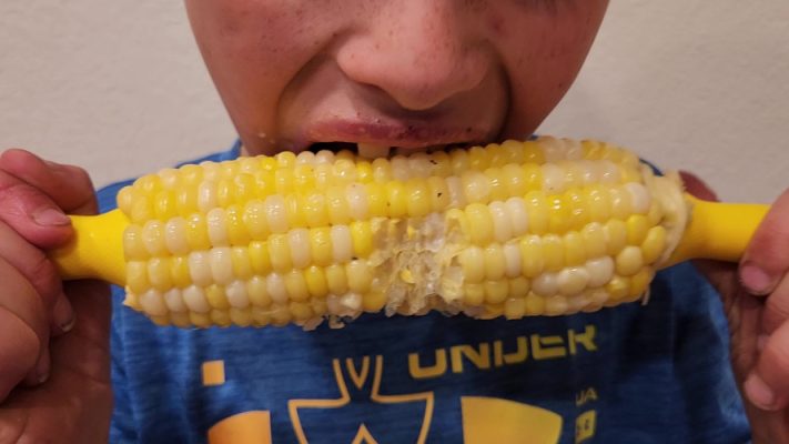Person eating an ear of corn.