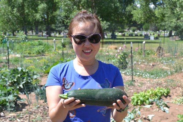 Woman holding a cucumber.