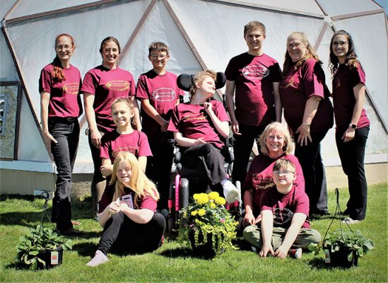 Students in front of a greenhouse.