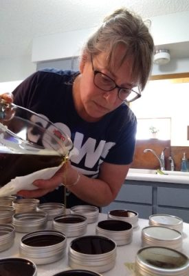 Woman pour hand balm into tins