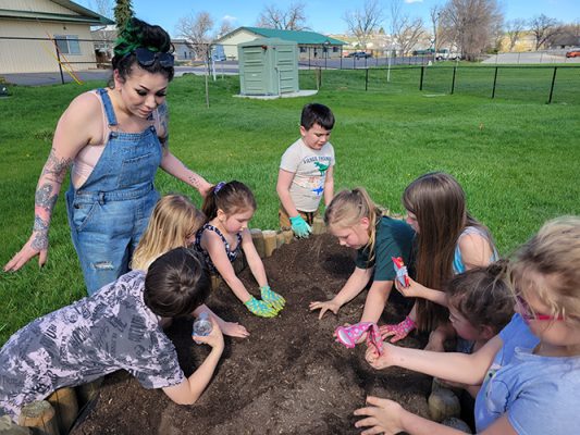 Henry-Coffeen-Garden-500h Teacher and students working in a garden