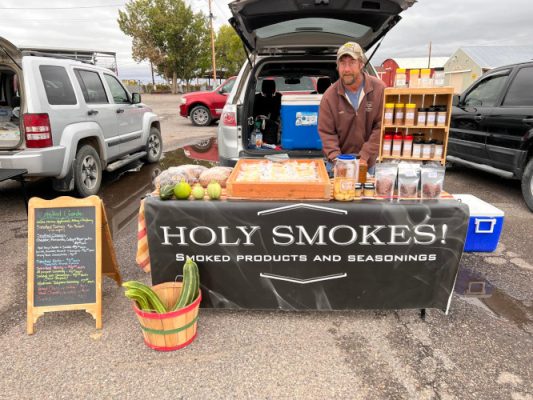 Holy Smokes! table with man behind.