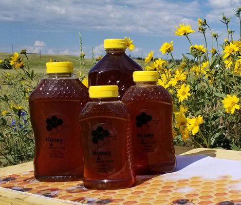 Bottles of honey outside on a table.