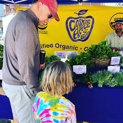 Adult and child buying vegetables