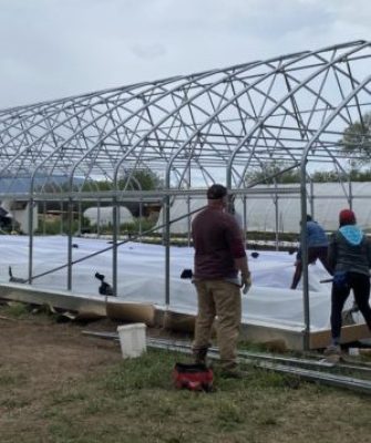 People building a high tunnel.
