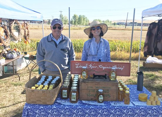 Couple behind table with honey products