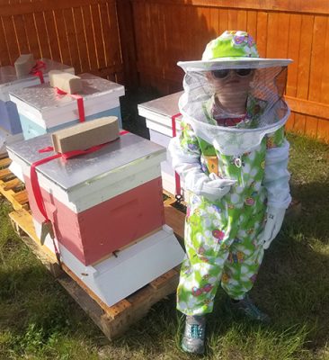 Child next to bee boxes