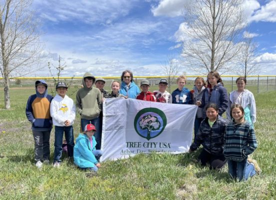 Kids in an orchard with a sign