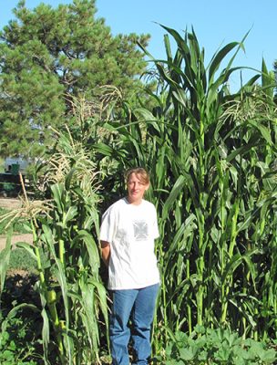 Woman standing beside corn field