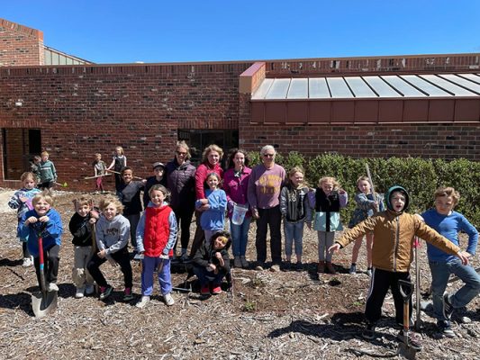 Children and teachers in front of an elementary building
