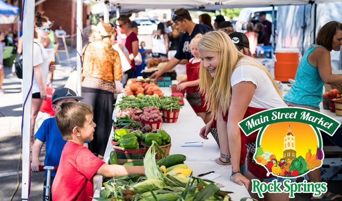 Woman helping a child at a farmers market.