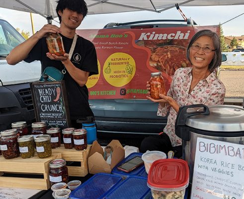 Two people at farmers market stand