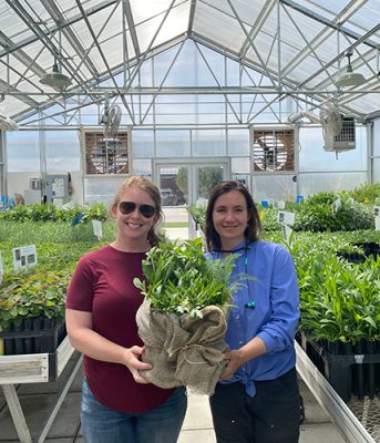 Two women holding plants