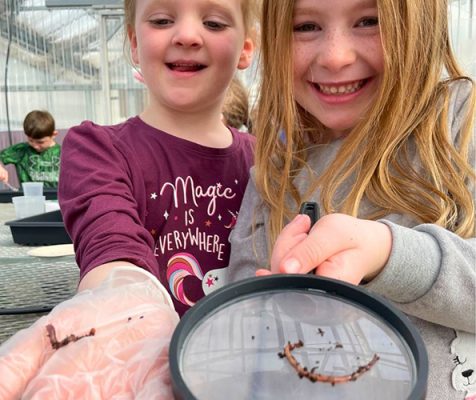 Two girls holding worms