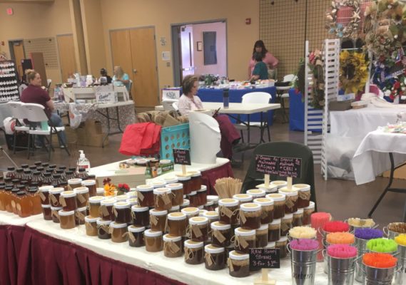 Homemade canned goods on a table at a market.
