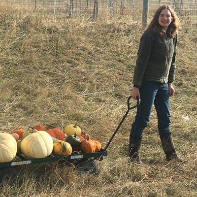 Woman pulling wagon of pumpkins