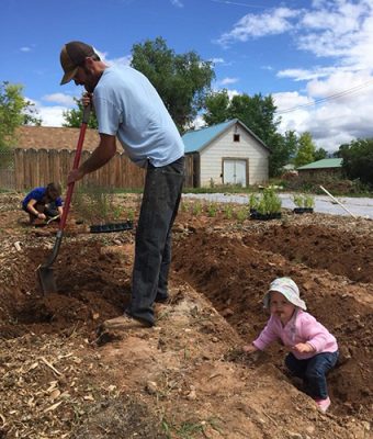 Man with child digging in a garden.