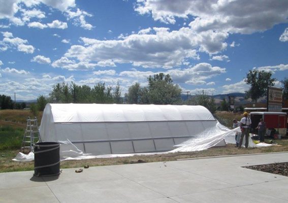 People constructing a hoop house
