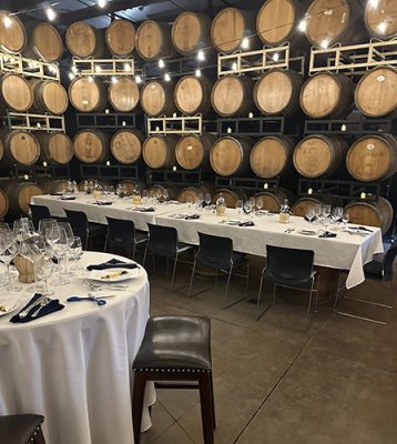 Tables set up next to wine barrels