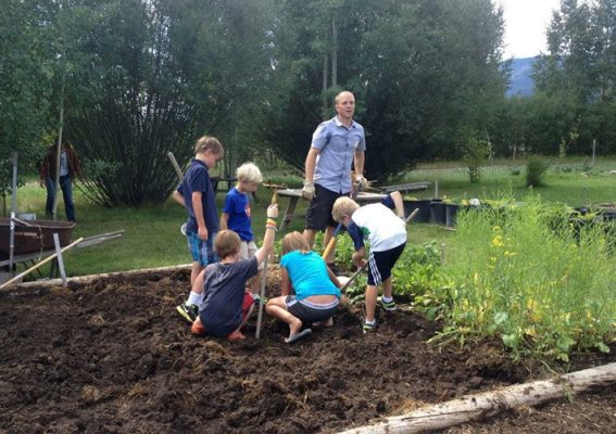 Adult and children working in a garden.
